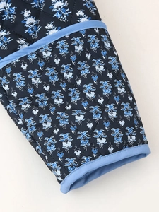 Close-up of diamond quilted cuff with blue floral pattern and light blue piping detail
