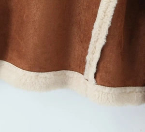Detailaufnahme des braunen Wildlederjackensaums mit weichem weißem Lammfellfutter