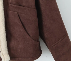 Detail of faux suede jacket showing side pocket and soft white sherpa lining texture