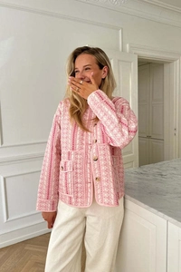 Detail of pink floral quilted jacket with large amber buttons and flap pockets