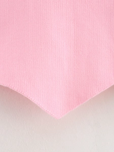 Detailaufnahme der rosa Strickweste mit feiner Textur und spitz zulaufendem Saumdesign