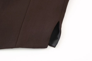 Close-up of deep coffee vest pocket detail showing fine twill fabric and premium stitching