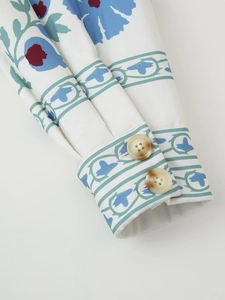 Detail of sleeve cuff featuring blue floral print and dual faux marble buttons