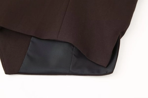 Detailed close-up of premium twill fabric vest hem with smooth black silk lining