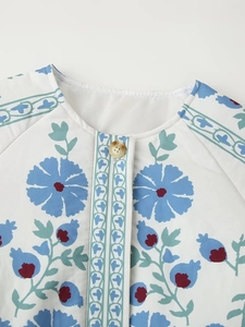 Close-up of bohemian blue floral print jacket with round neck and raglan sleeve detail