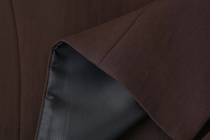 Close-up of premium dark brown fabric with striped lining for casual women's suit set