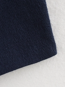 Detailed macro view of high-quality navy blue knitted fabric texture and soft fine stitching