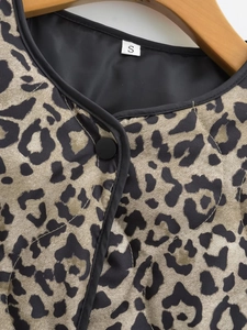 Detail shot of leopard print quilted jacket with diamond stitching and black piping trim