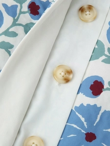 Close-up of blue floral print cotton jacket featuring amber-textured round buttons