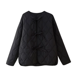 Detail of black quilted jacket with bow ties and wave pattern stitching for women