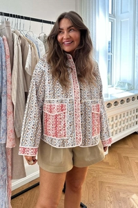 Close-up of quilted floral jacket with vintage patchwork patterns and high waist khaki shorts