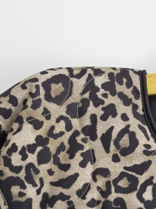 Close-up of leopard print quilted jacket showing fabric texture and black trim detail