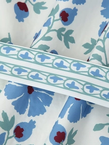 Close-up of floral pattern fabric with decorative woven ribbon on winter padded coat