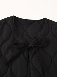Women's black quilted vest featuring elegant bow ties and diamond stitch pattern