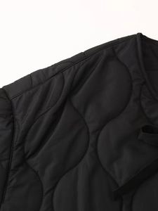 Detail of black quilted jacket showing gourd pattern stitching and premium nylon fabric texture