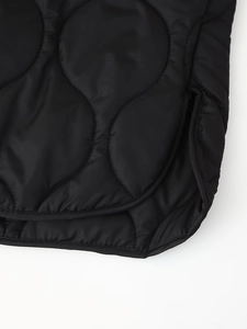 Macro shot of wavy quilted black fabric with side slit and rounded hem details