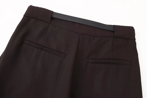 Detail view of the high-waist dark brown trousers featuring back pockets and elastic waistband