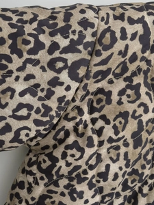 Macro shot of quilted leopard print fabric with diamond stitching on autumn jacket