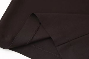 Detailed macro view showing the twill fabric texture and hem stitching of the trousers