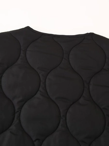 Detail of black onion-quilted lightweight fabric with rounded neckline craftsmanship