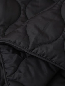 Detail of black quilted cotton jacket with high-quality arch-shaped stitching and silk sheen