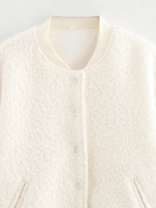 Detail of white sherpa jacket showing ribbed collar, snap buttons and soft fuzzy texture