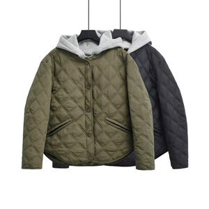 Detail view of olive and black quilted jackets with contrast hood and curved hem design