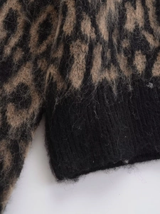 Dettaglio del maglione leopardato in maglia con trama soffice e polsini neri a coste