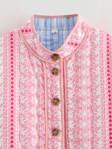 Close-up of floral quilted jacket with marble buttons and contrast pink piping trim