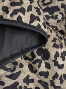 Detail of leopard print quilted fabric featuring black bound edges and neat stitching