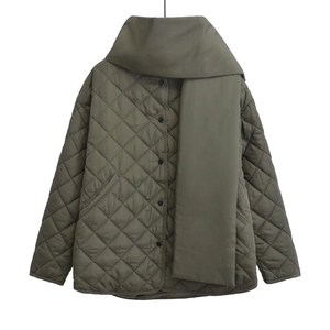 Détail d'une veste matelassée vert armée avec motifs en losanges et écharpe assortie