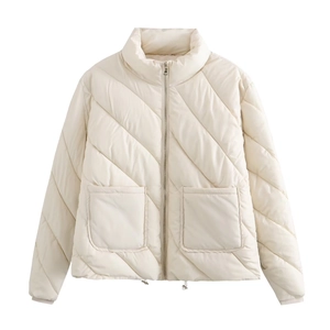 Detail view of cream diagonal quilted jacket featuring stand collar and large front pockets