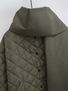 Détail de la veste matelassée vert olive montrant le motif en losange et les boutons