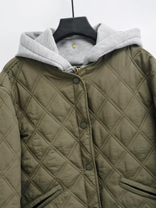 Detail of army green diamond-quilted jacket with gray knit hood and button-up front