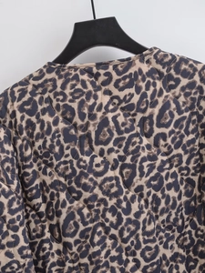 Detail der gesteppten Jacke mit Leopardenmuster, Wellennähten und Rundhalsausschnitt