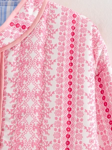 Detailed view of quilted cotton coat featuring floral prints and blue striped lining