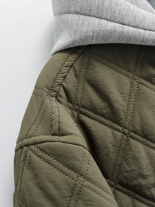 Detail view of army green quilted cotton jacket with grey knit hood and diamond stitching