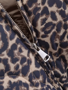 Makroaufnahme des silbernen Metallreißverschlusses an der gesteppten Leopardenjacke