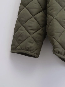 Détail de la veste matelassée vert armée avec surpiqûres en losanges et bordures nettes