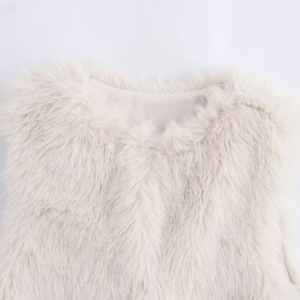 Detailed view of white faux fur vest neckline featuring plush texture and neat inner lining