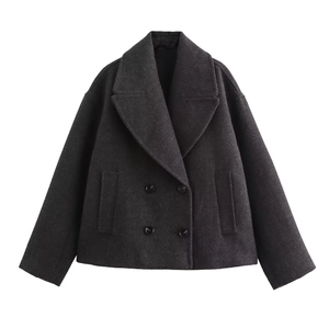 Detailed close-up of dark grey double-breasted wool jacket with classic lapels and buttons