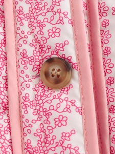 Detailed close-up of pink floral fabric with high-quality resin button and fine stitching