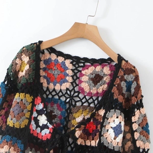 Detail of bohemian handmade crochet cardigan with colorful granny squares and black stitching
