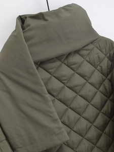 Détail du tissu matelassé vert armée avec motif en losanges et texture lisse