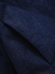 Macro shot of dark blue denim jacket with diamond quilting and thick twill texture details