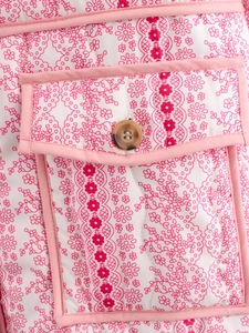Detail of pink floral quilted jacket featuring a flap pocket with tortoiseshell button