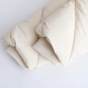 Detail of windproof ribbed cuffs on cream quilted jacket with high-quality stitching