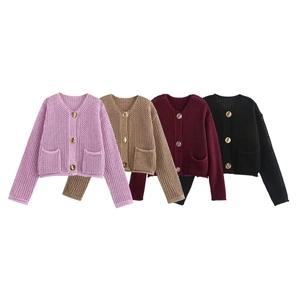 Detailed view of hollow knit textures and gold metal buttons on colorful women's cardigans