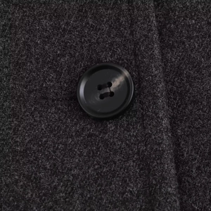 Close-up of black resin buttons on dark grey wool blend coat with thick texture