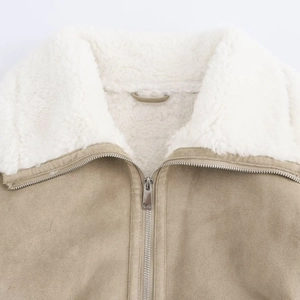Dettaglio della giacca scamosciata color cammello con colletto in sherpa bianco e zip